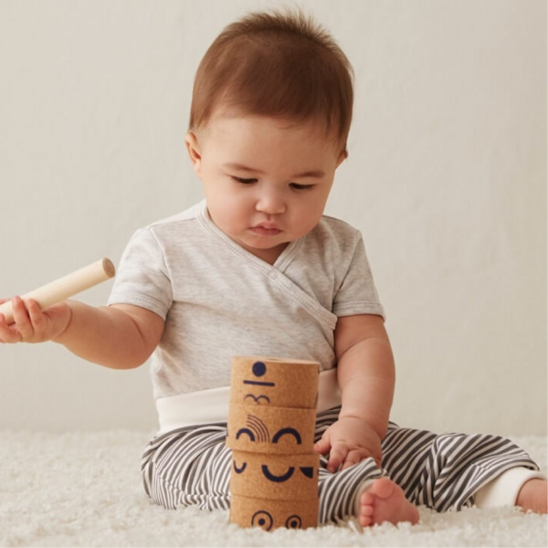 A baby stacking a toy