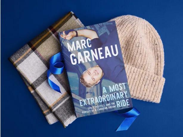 Cadeaux pour les aventuriers et aventurières, incluant une écharpe et le livre A Most Extraordinary Ride par Marc Garneau.