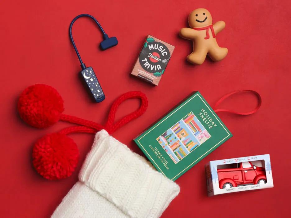 A book light, mini puzzle and music trivia cards spilling out of a knit Christmas stocking.