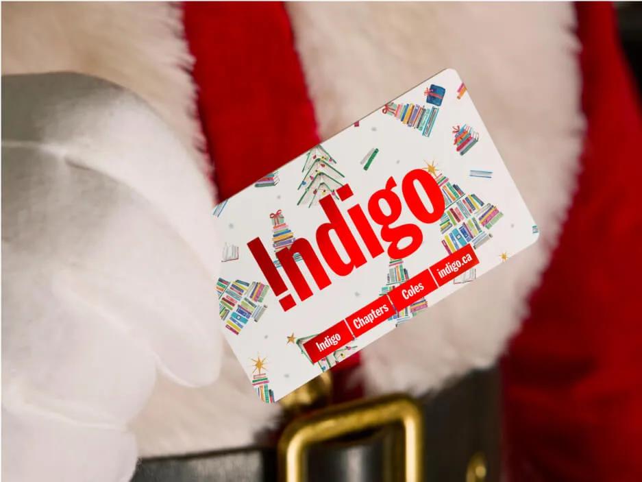 A gloved hand holding an Indigo gift card.